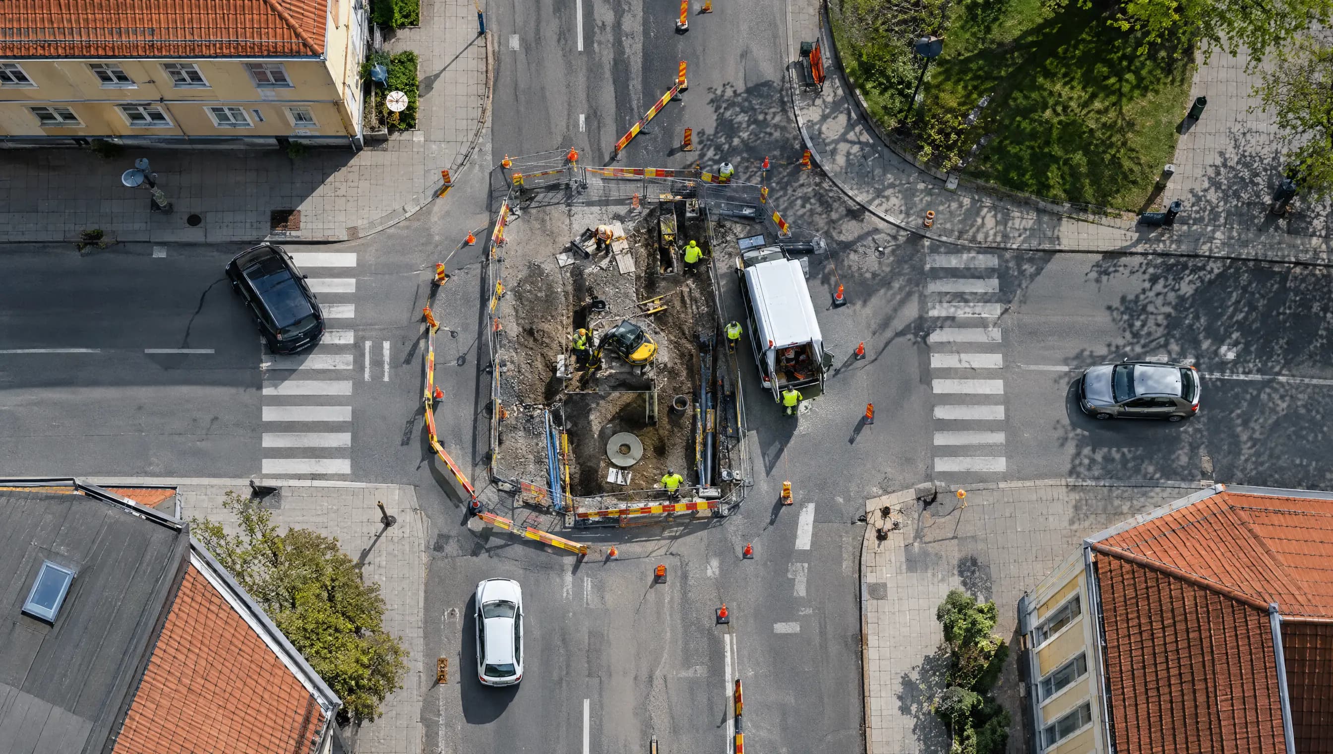 Drönarbild över ett vägarbete i en korsning med koner och avspärrningar